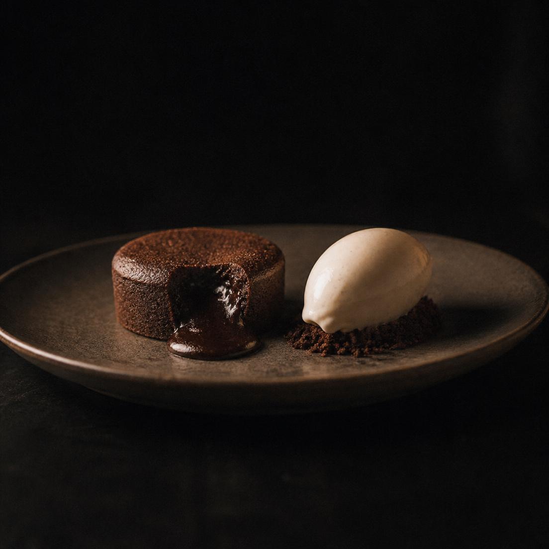 Dark chocolate fondant with vanilla ice cream on a matte plate