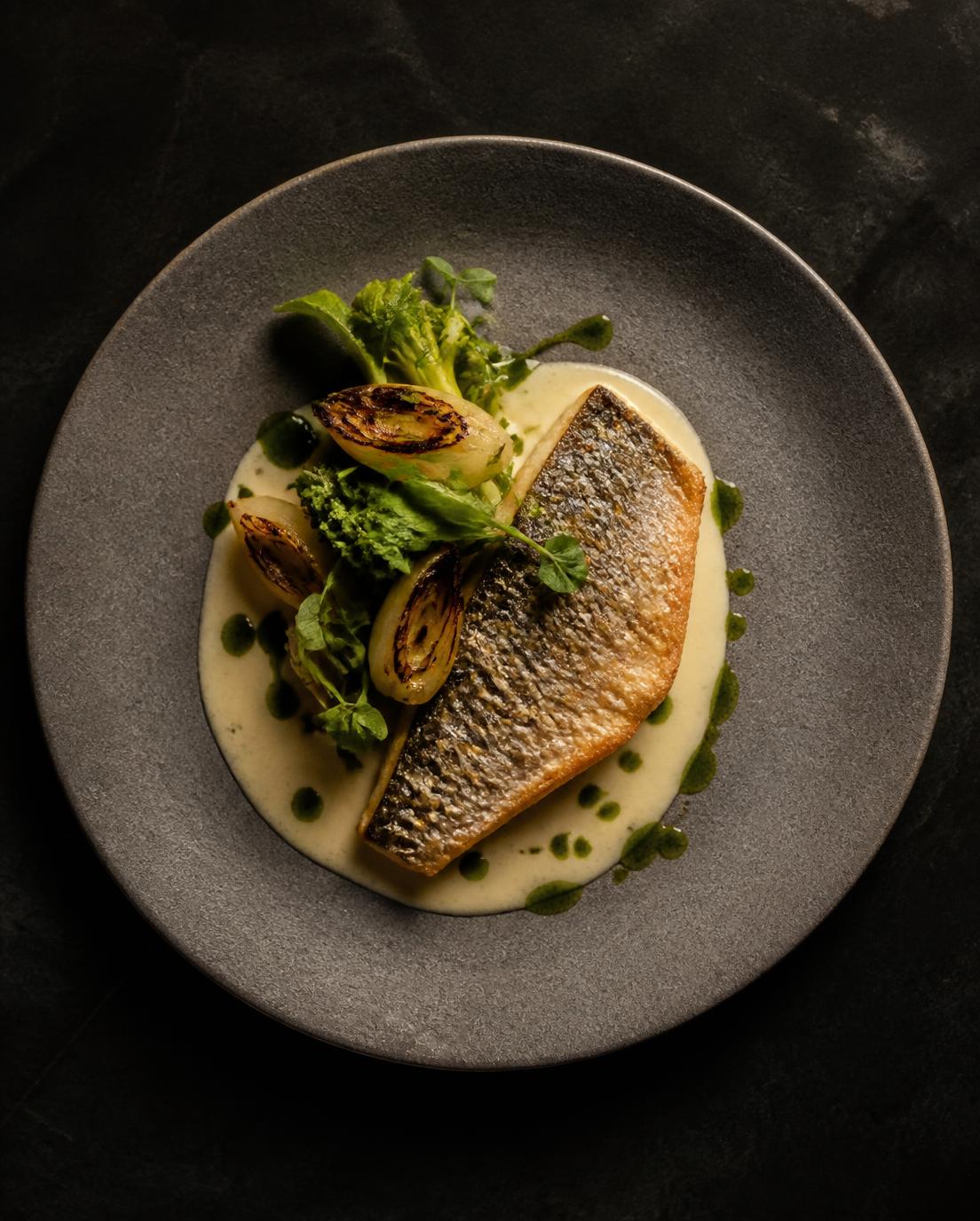 Wild sea bass fillet with lemon beurre blanc and seasonal greens